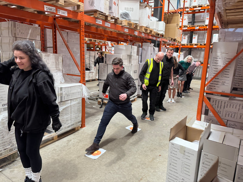 HALCO employees in a warehouse doing a team excersise